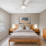 Bedroom with bed, dresser and bright window